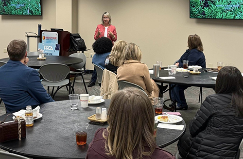 Jackie at front of meeting room facilitating workshop